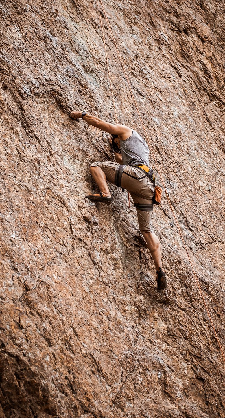 Hombre escalando pared vertical